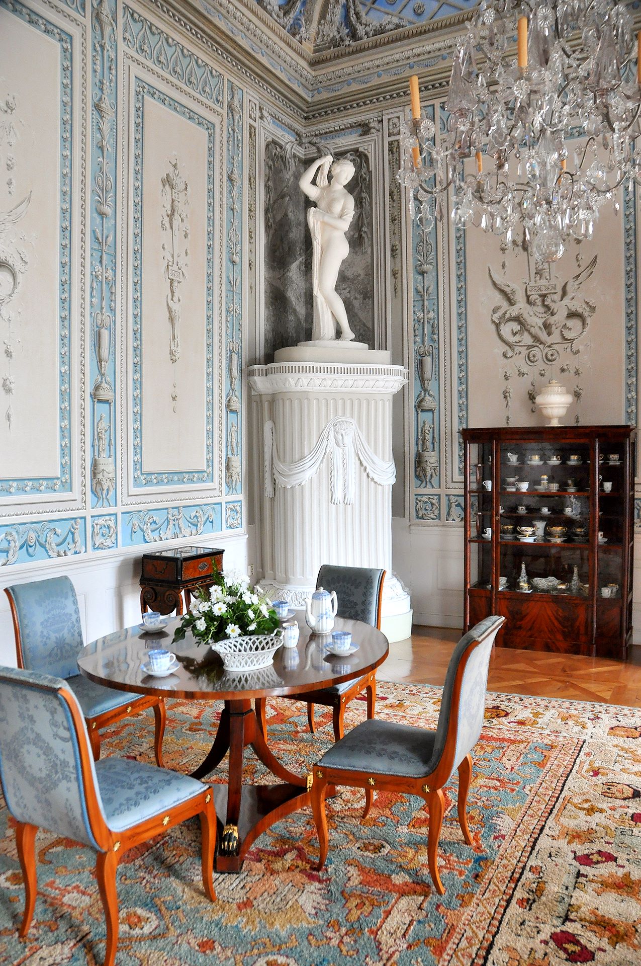 Der Blaue Salon mit Möbeln im Stil des Empire und Aphrodite am Kachelofen