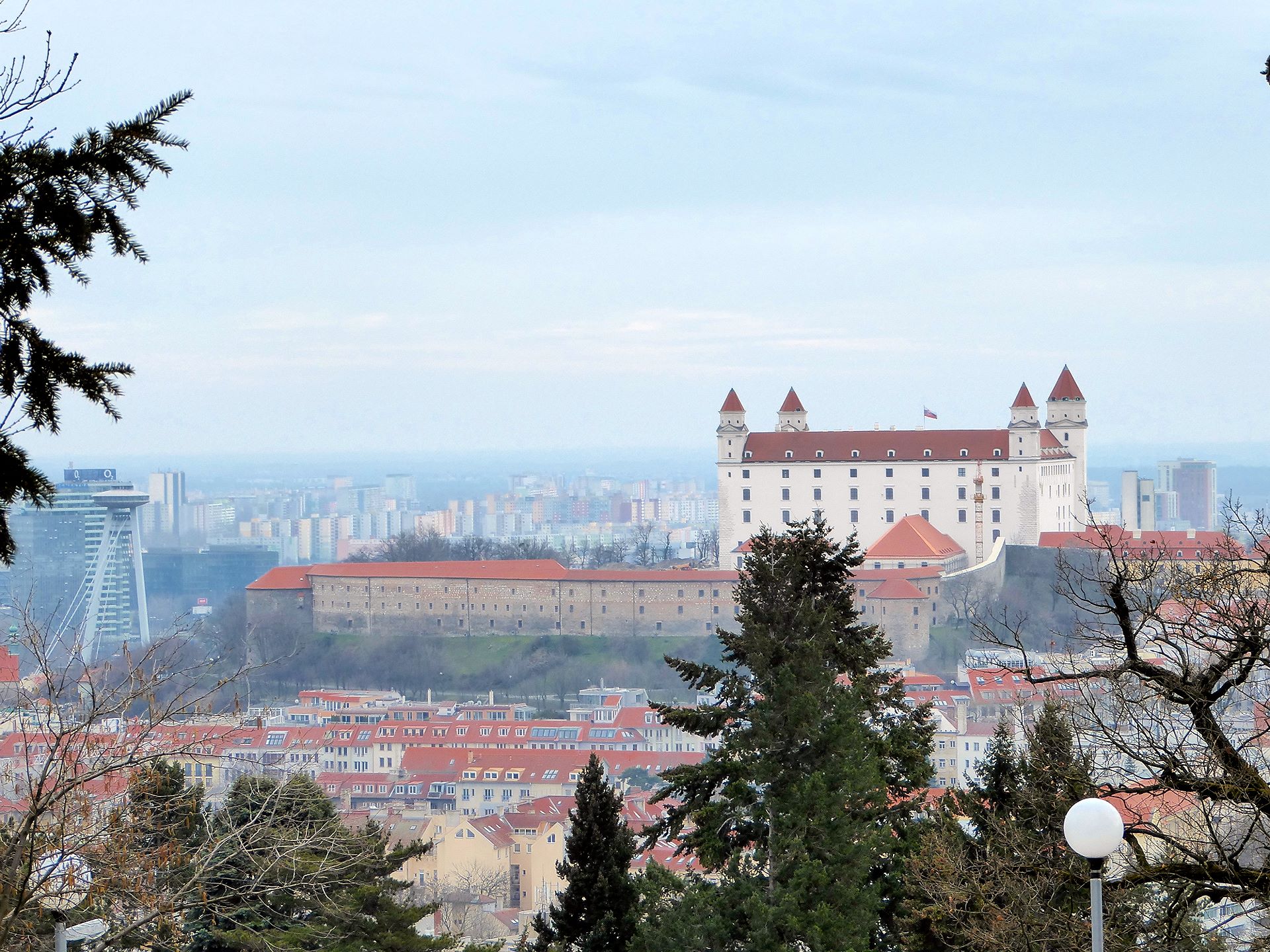Blick auf die Bratislaver Burg vom Slavín-Hügel, das Ufo links daneben dient als Ausssichtsplatform im Pfeiler einer Donaubrücke 