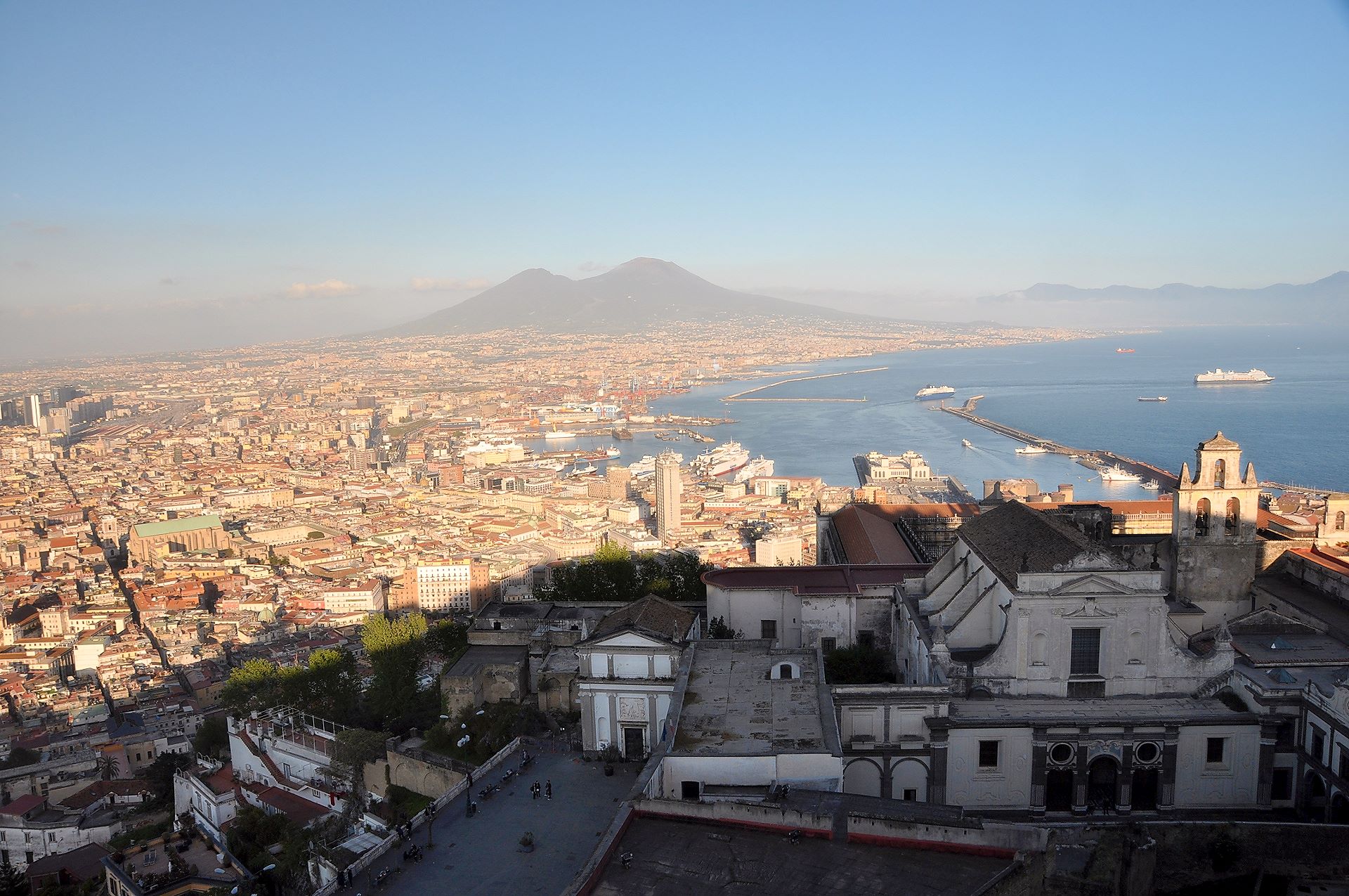 Stadtzentrum und Hafen von Neapel mit dem Vesuv im Hintergrund